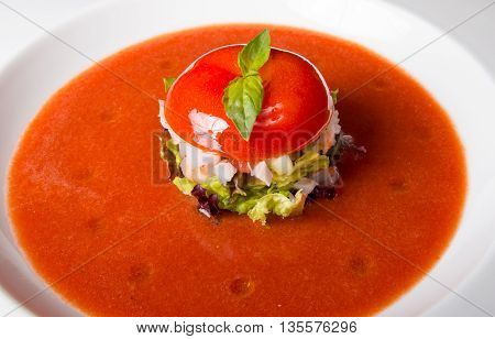 Tomato gaspacho soup on a white plate