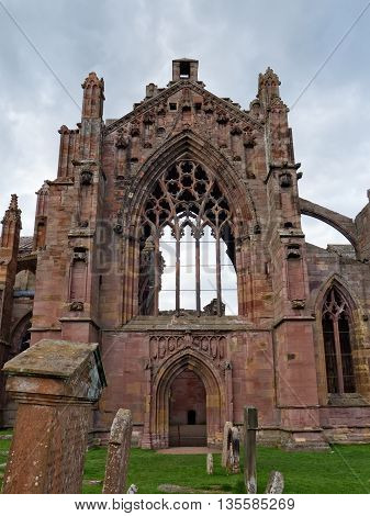 The ruins of pink colored Melrose Abbey in the Scottisch Borders region in Scotland