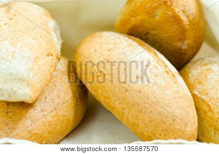 Selection of delicous bread buns lying in basket, as seen from above.