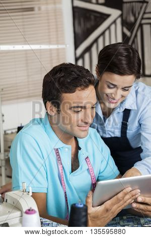Fashion Designers Discussing Over Digital Tablet