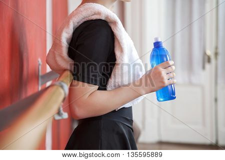 Midsection Of Ballerina Holding Waterbottle In Studio