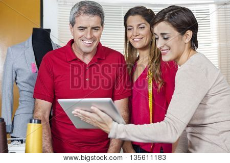 Tailors Using Digital Tablet In Factory