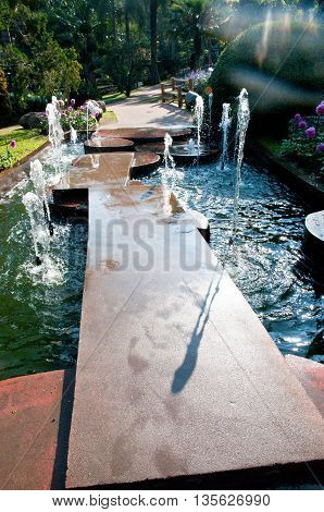 A fountain in the pathway of a garden.