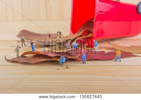 Image Of Mini Figure Dolls Worker Collect Dry Leaves Into The Red Recycle Bin .