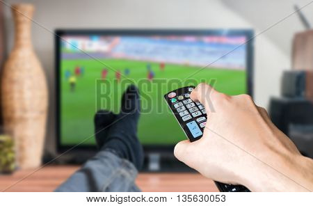Man Is Relaxing With Legs On Table And Is Watching Football Matc