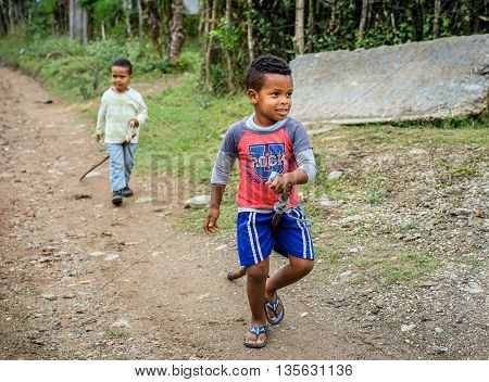 Trinidad Cuba - January 14 2016: Two adorable little boys playing with their homemade stick horses hobbyhorse in a poor district near Trinidad