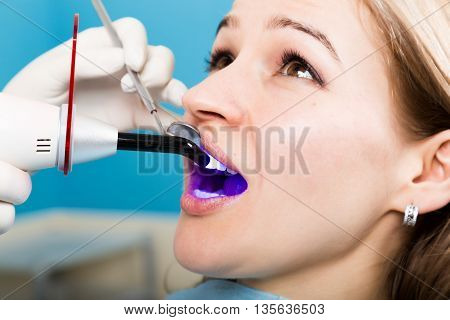 The reception was at the female dentist. Doctor examines the oral cavity on tooth decay. Caries protection. doctor puts the patient an anesthetic injection. close-up of the patient's mouth and squirt.