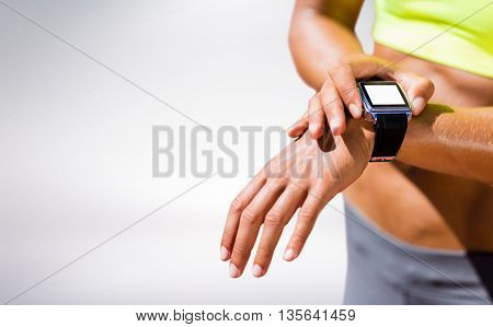 Close up on a sportswoman wearing a connected watch against grey background