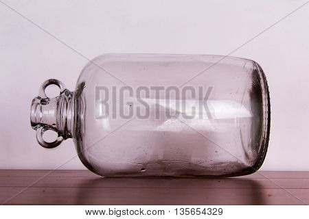 Clear Glass Demijohn Against A Light Background