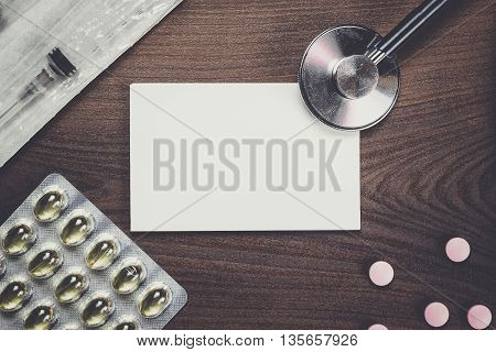 blank notebook statoscope and pills on dark brown wooden table