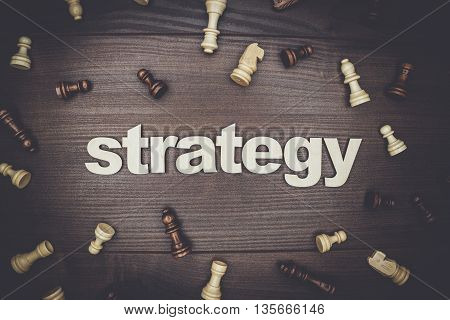 word strategy and chessmen on the brown wooden background