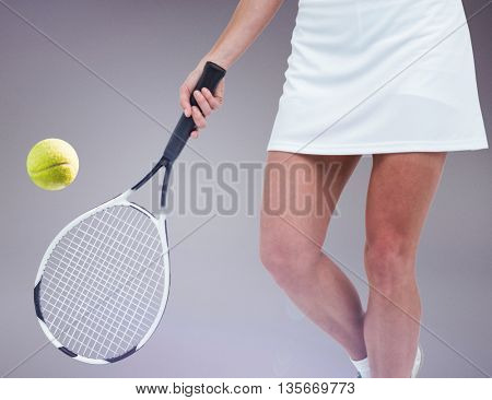 Athlete playing tennis with a racket against grey background