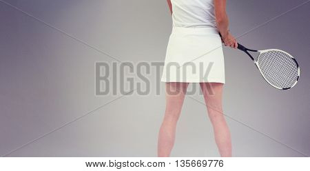 Athlete playing tennis with a racket against grey background