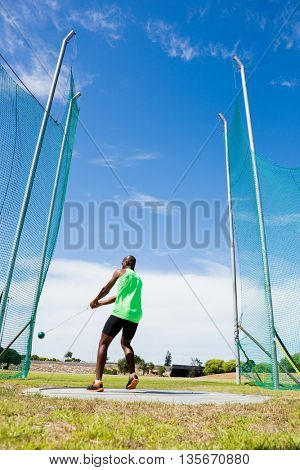 Athlete performing a hammer throw in stadium