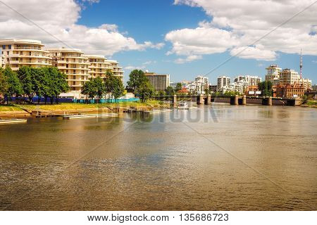 Modern residential area on the riverbank. Idyllic warm toned landscape at sunny day. Saint Petersburg Russia