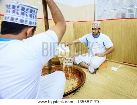 NIZWA, OMAN, MAY 27, 2016: factory workers adding ingredients to a kettle for making of traditional Omani halwa