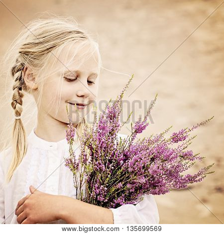 Young Girl Outdoors. Happy Girl with Heather Flowers in Great Britain Heath