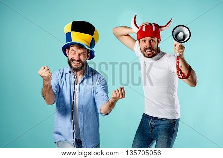 The two football fans with mouthpiece over blue background