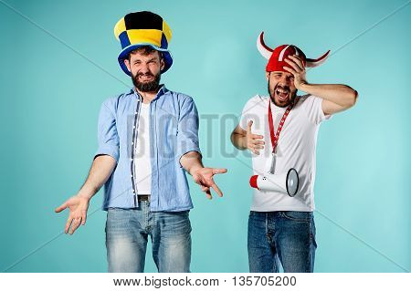 The two football fans with mouthpiece over blue background