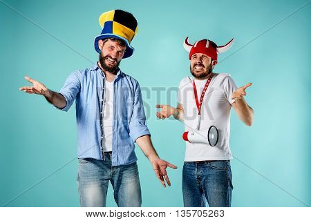 The two football fans with mouthpiece over blue background