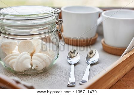 The meringues in glass jar on tray