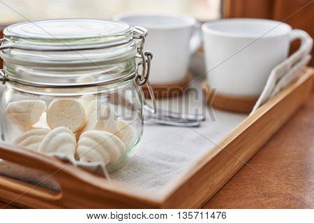 The meringues in glass jar on tray