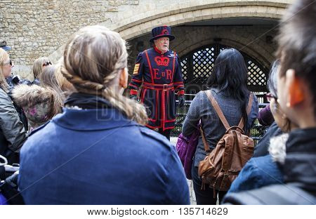 LONDON UK - APRIL 10TH 2016: A Yeomen Warder talking to visitors during a tour of the historic Tower of London on 10th April 2016.