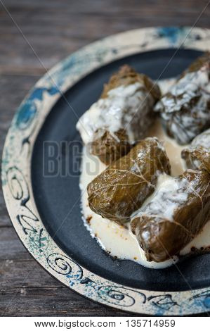A plate with Romanian sarmale - stuffed vine leaves