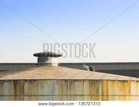 Lonely laber welding on rooftop of big tank