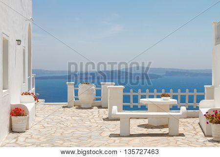 white bench against Aegan sea and volcano caldera, beautiful details of Santorini island, Greece