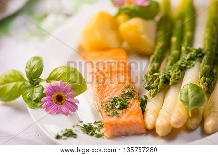 Salmon fillet with green asparagus and edible flowers