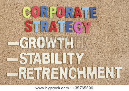 Alphabet wood letters of corporate strategy growth stability retrenchment words on wooden board, Top view, Strategy business concept