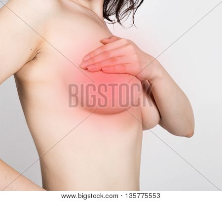 Breast cancer self check. Young woman examining her breast for lumps or signs of breast cancer. healthy lifestyle concept.