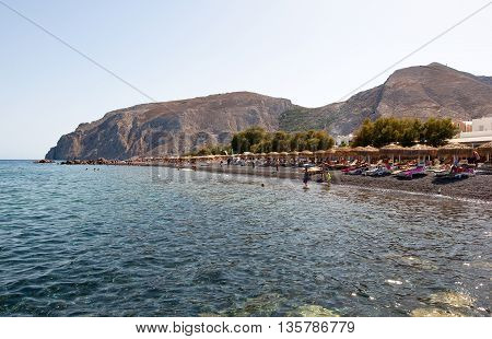 Tourists sunbathe on the Kamari Beach. SantoriniGreece.
