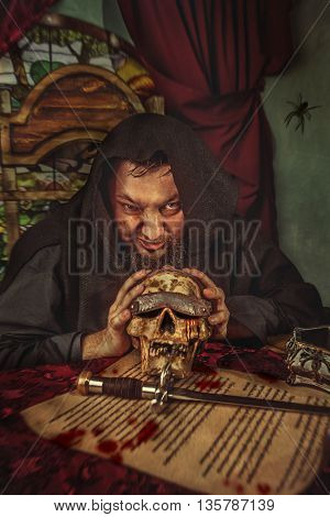 Unkind Medieval Fat Monk In Sitting In The Dark Room With The Skull.