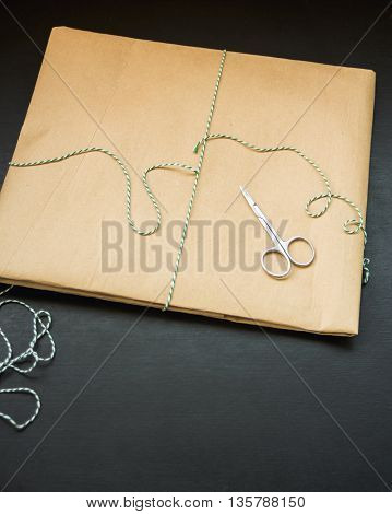 gift packing in kraft paper and tied green thread