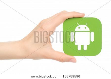 Kiev Ukraine - May 18 2016: Hand holds Android logo printed on paper on white background.