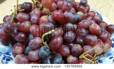 Fresh grapes in a blue bowl on a marble table