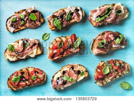 Brushetta snacks for wine. Variety of small sandwiches on turquoise blue backdrop, top view