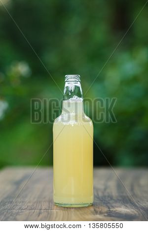 homemade lemonade in glass bottle on bokeh background. Lemon beer.