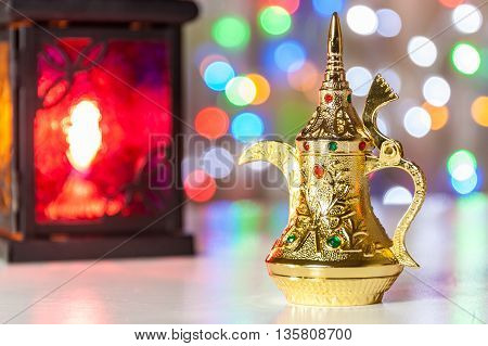 Gold Arabic Coffee pot in colorful illuminated background. Ramadan and Eid Mubarak concept background