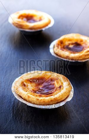 Egg tart on a grunge background, traditional portuguese dessert, pasteis de nata. Selective focus