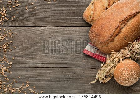 Bread and and wheat on a wooden table