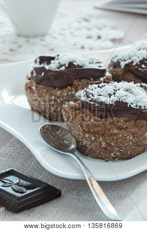 A photo of chocolate cakes on a white plate with a spoon