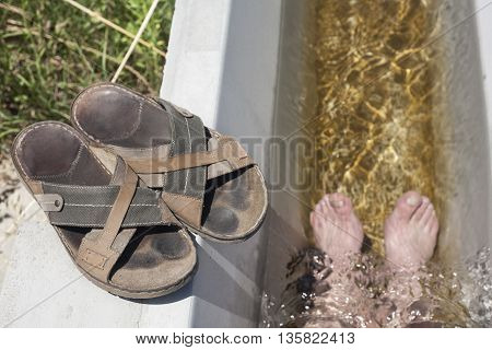 Man feet refreshing in a cool irrigation canal during the hottest day hours Vegas Altas del Guadiana Spain