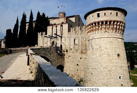 Brescia, Italy - May 30, 2006: A sloped roadway leads to the portcullis and entrance gate to the feudal era 1343 fortified Castello built by the Visconti family