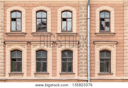 Several windows in a row on facade of urban apartment building front view St. Petersburg Russia
