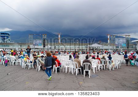 QUITO, ECUADOR - JULY 7, 2015: Lots of people sitting on white chairs waitting for pope Francisco mass. Firts time for him in Ecuador.