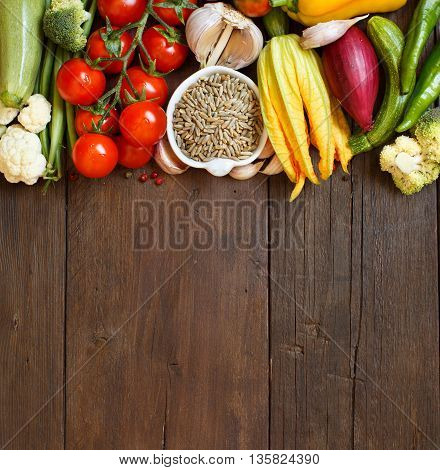 Raw Rye Grain in a bowl and vegetables on wood