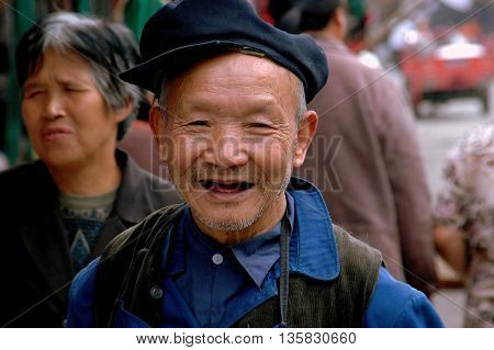 Ao Ping China - September 14 2006: Smiling elderly toothless Chinese man wearing a cap